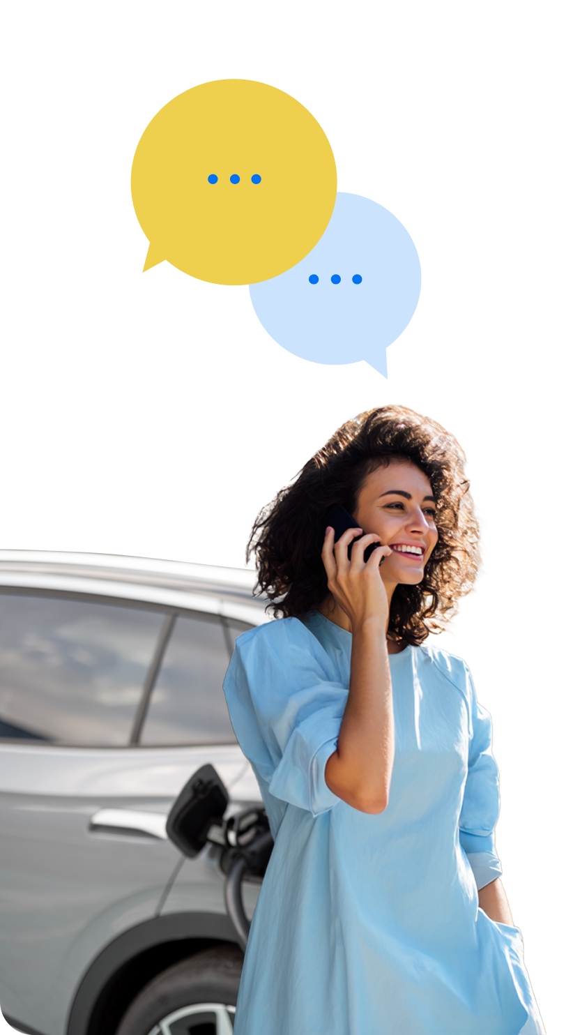 Tüdruk, oma elektriauto vastu nõjatudes, räägib telefoniga.