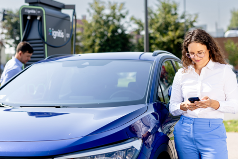 Naine laeb elektriautot Ignitis ON laadimisjaamas