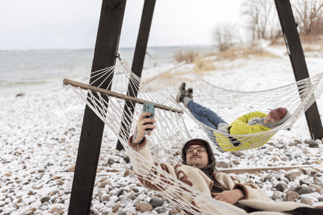 Mees lõõgastub koos lapsega võrkkiiges.