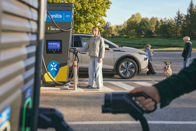 Naine laeb elektriautot Ignitis ON laadimisjaamas.