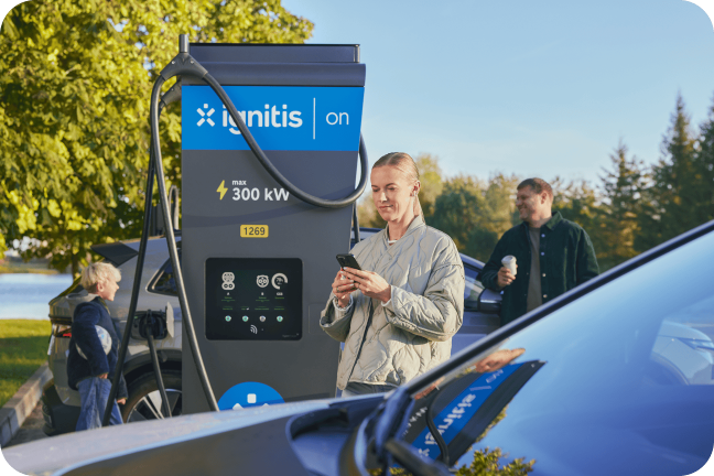 Naine laeb koos perega elektriautot Ignitis ON ülikiire laadimise jaamas.